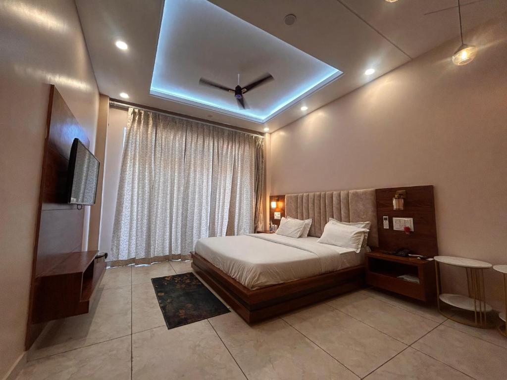 a bedroom with a bed and a window with a ceiling at The Satluj Vista in Bilāspur