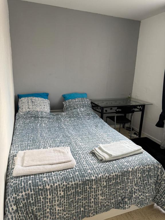 a bedroom with a bed with two towels on it at Chez Dapia in Saint-Denis-en-Val