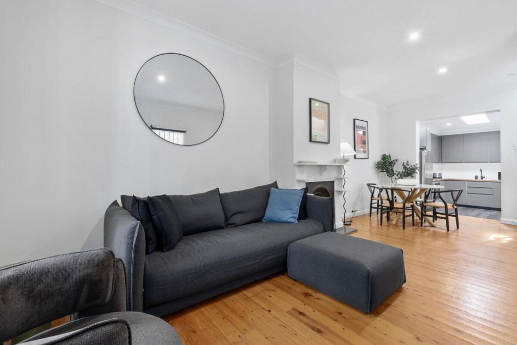 a living room with a gray couch and a table at Comfortable 3BR Home for 8 Near Central Station in Sydney