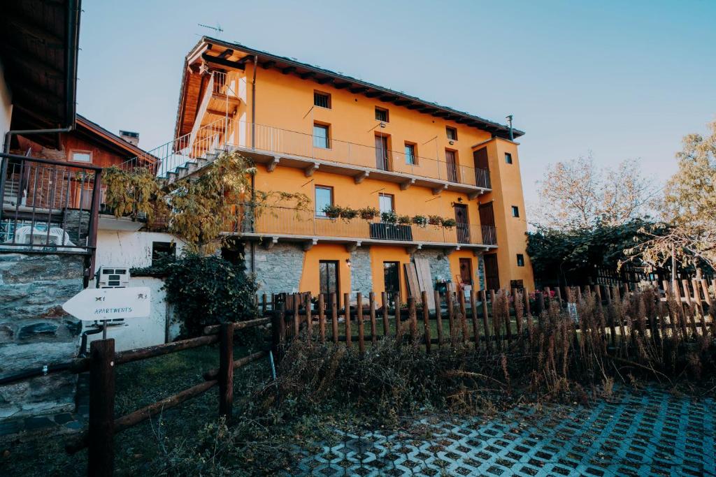 an orange building with a fence in front of it at Stars Apartments Gressan in Cerise