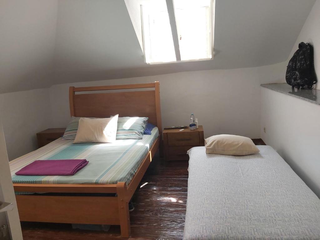 Un dormitorio pequeño con dos camas y una ventana. en FeliGrab, en Mindelo