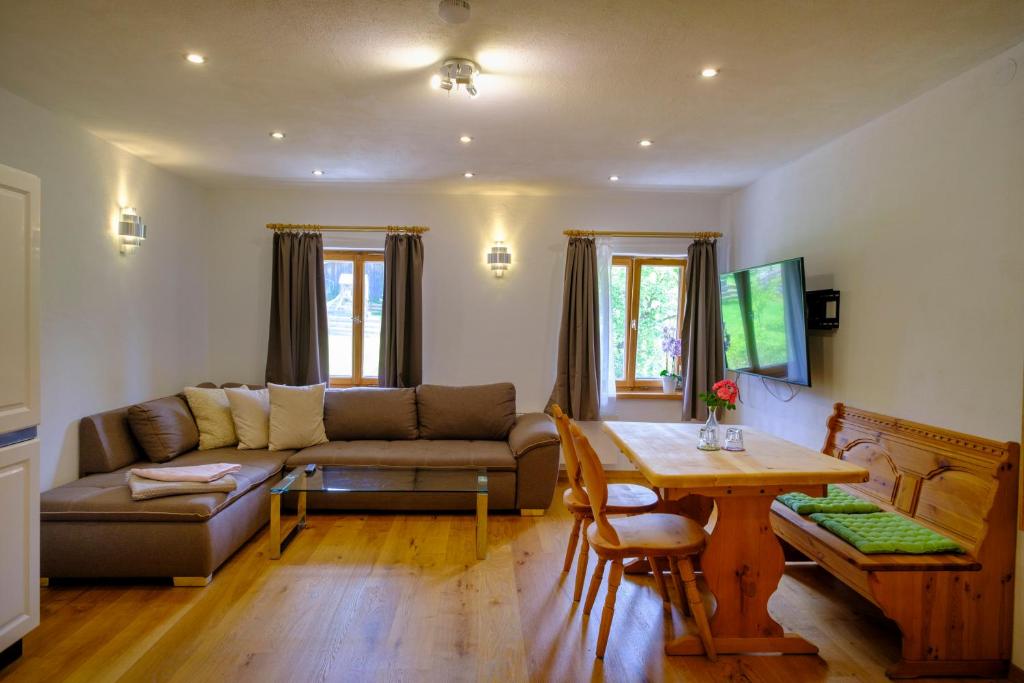 a living room with a couch and a table at Zum Friedl in Wackersberg