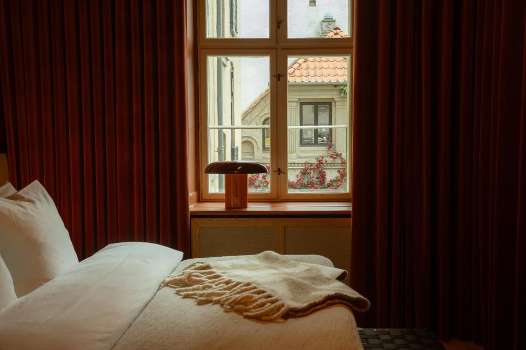 a bedroom with a bed and a window with a view at Four Suites Copenhagen in Copenhagen