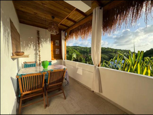 d'un balcon avec une table et une grande fenêtre. dans l'établissement Aloès, T2 résidence Le Loys à Ste Anne, à Sainte-Anne