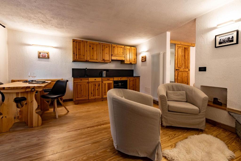 eine Küche mit Holzschränken und einem Tisch und Stühlen in der Unterkunft Lo Péyo - Le Four des Alpes in Rhemes-Saint-Georges