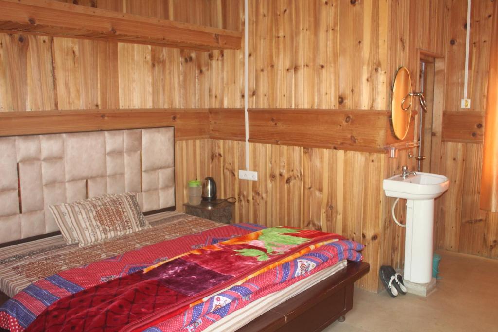 a bedroom with a bed and a sink in it at Hotel SSS The Chanshal Retreat in Khashdhār