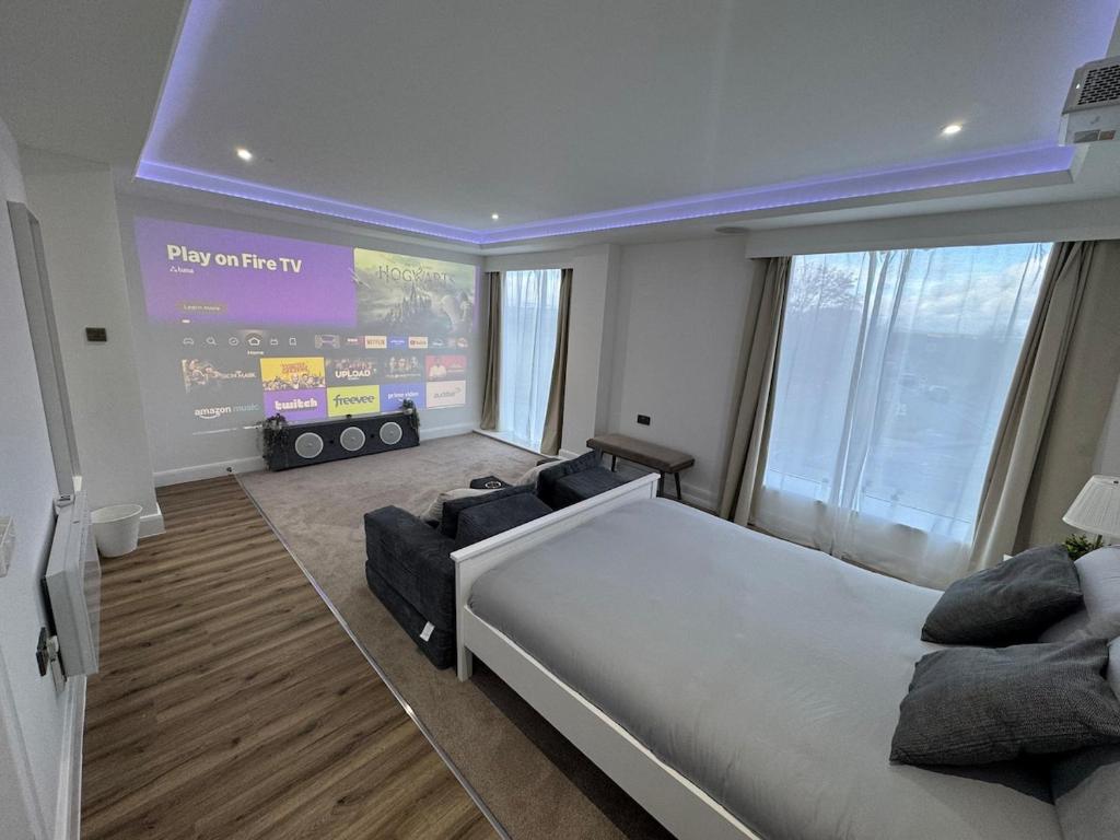 a bedroom with a large bed and a large screen at Cinema room apartment 2 in Basildon