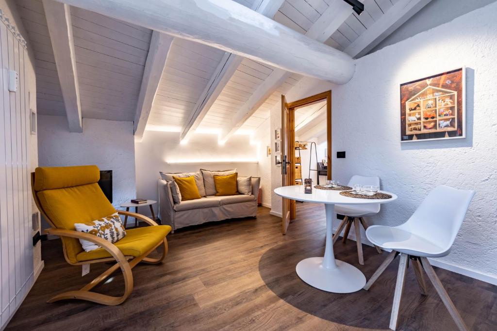 ein Wohnzimmer mit Tisch und Stühlen und einer Couch in der Unterkunft Petit Câlin - Le Four des Alpes in Rhemes-Saint-Georges