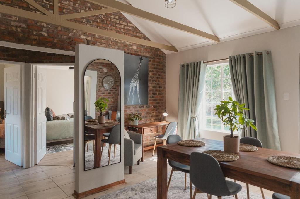 a dining room and living room with a brick wall at Welverdiend - Unit 1 in Bloemfontein