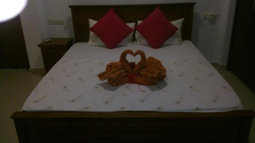 a bed with two stuffed animals in the shape of a heart at Hiri Relax Hostal in Dickwella