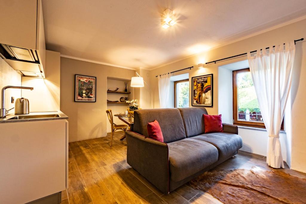 ein Wohnzimmer mit Couch und Küche in der Unterkunft Lo Micho - Le Four des Alpes in Rhemes-Saint-Georges