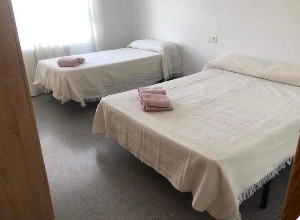 a room with two beds with white sheets at coparelia 2 in Villarrobledo