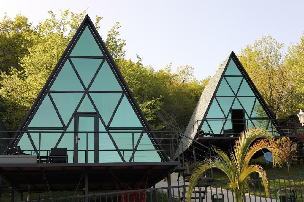 a house with glass windows on top of a fence at Panorama Sormoni in Dzhimastaro