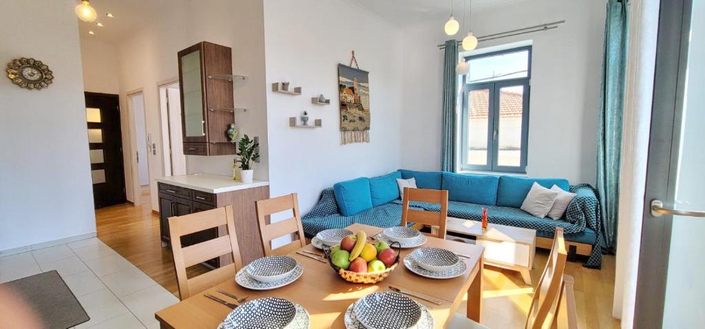 a living room with a table and a blue couch at Harmony Apartment Pythagoreio Samos Center in Pythagoreio
