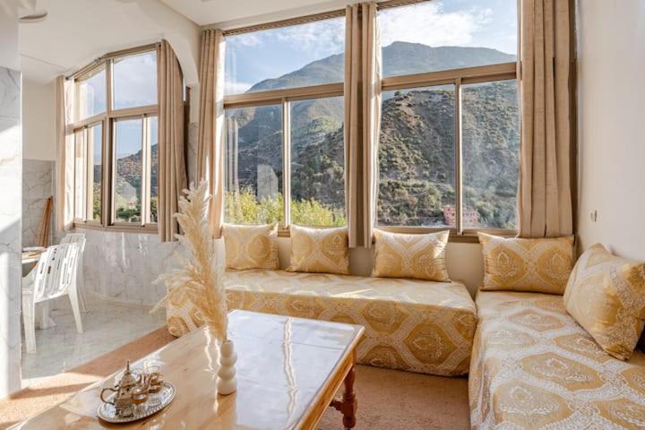 Una sala de estar con un sofá y grandes ventanales. en Dar Ourika - Mountain Views, en Ourika