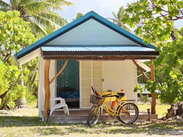 uma bicicleta estacionada em frente a uma pequena casa em Tetaha Lodge em Tiputa