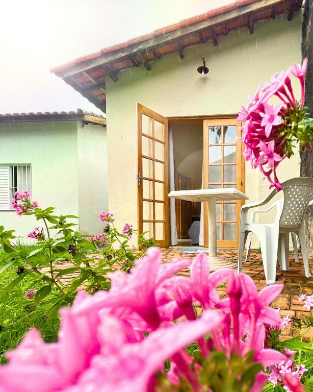 a house with pink flowers in front of it at Suíte no Jardim in Peruíbe