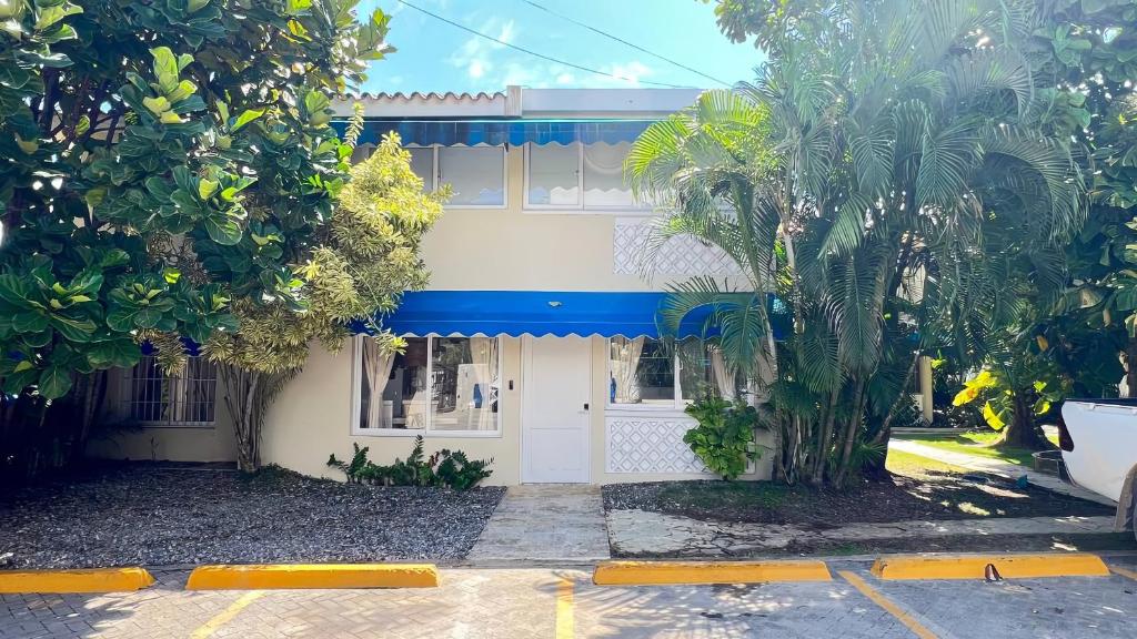 a white and blue building with trees in front of it at Villa Dominique in Villas del Mar