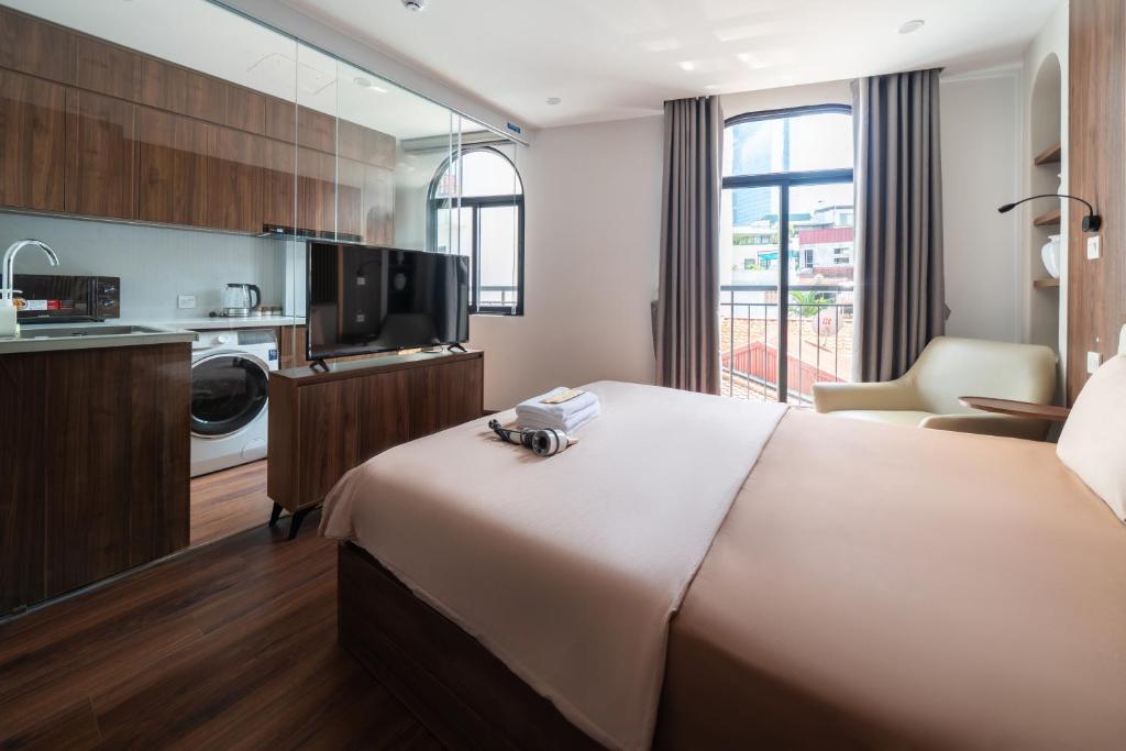 a hotel room with a bed and a kitchen at HNT Homestay Đào Tấn - Near Lotte Center in Hanoi