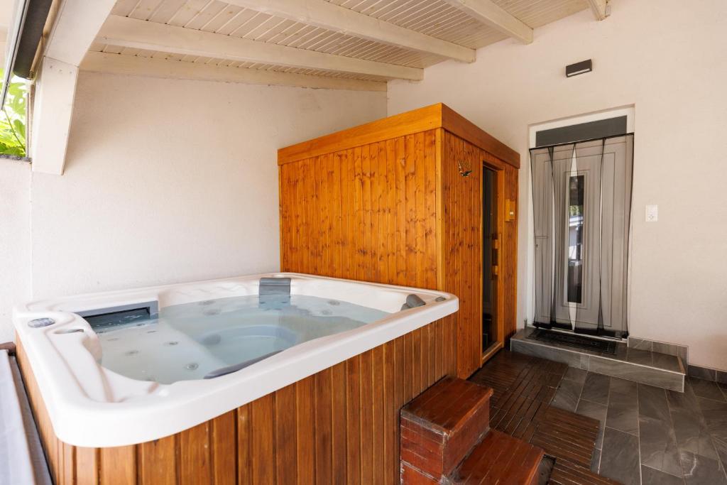 een jacuzzi in een kamer met een houten kast bij Csillag Vendégház Mórahalom in Mórahalom
