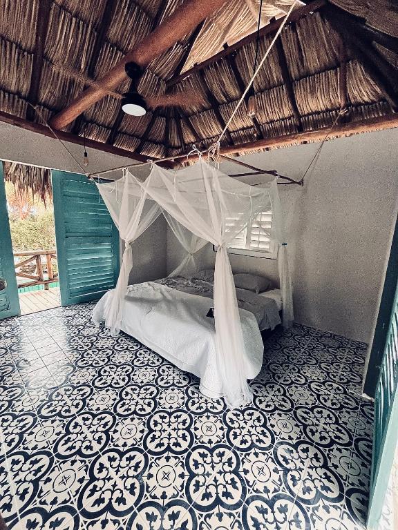 a bedroom with a bed with a mosquito net at KokohauBungalows in Santa Verónica