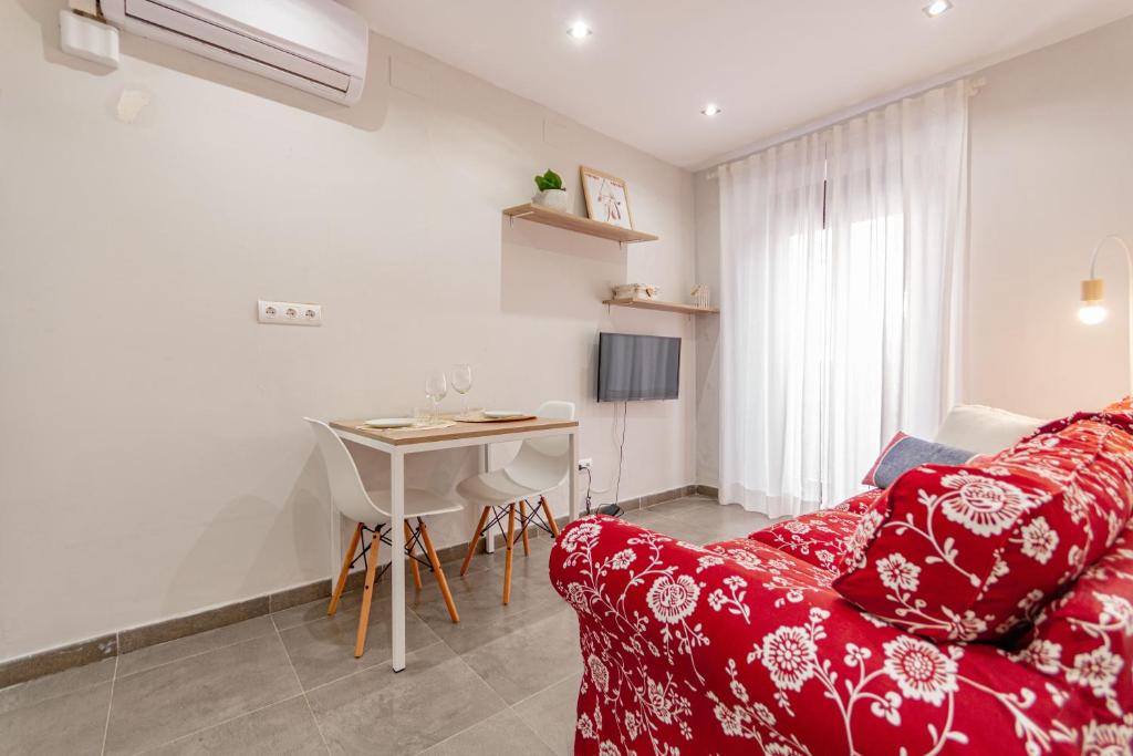 a living room with a red couch and a table at Marea Ferrers 1 in Tarragona