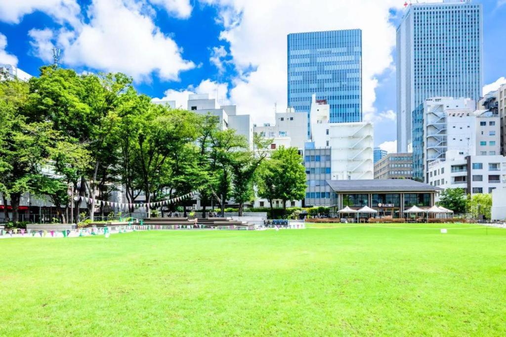 a park in a city with tall buildings at Poppy ikebukuro in Wada