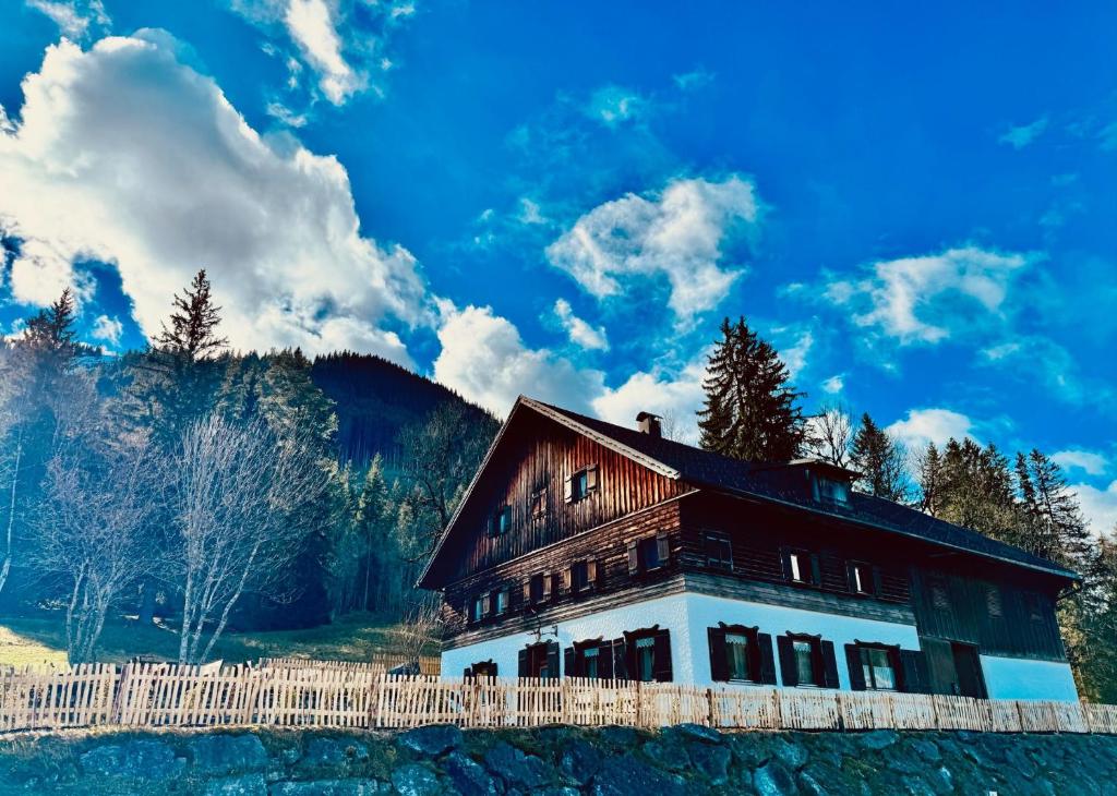 a house with a fence in front of a mountain at Haus Schönblick in Tannheim