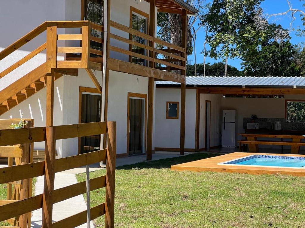 a house with a ladder next to a swimming pool at Suíte no Rancho Minas in Porto Seguro