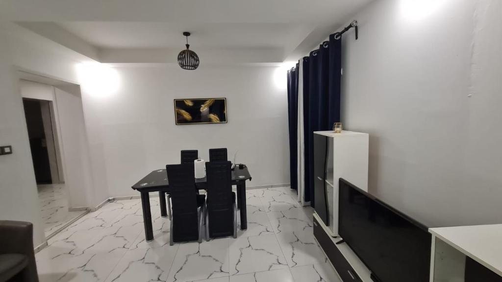 a room with a table and two chairs and a refrigerator at Ramela in Dakar