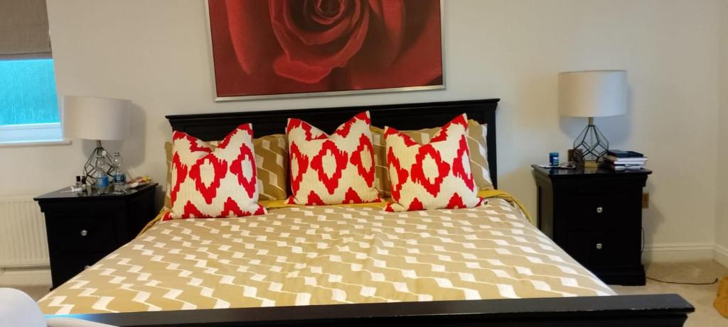 Un dormitorio con una cama con almohadas rojas y blancas. en 9 Church View, en Clapham
