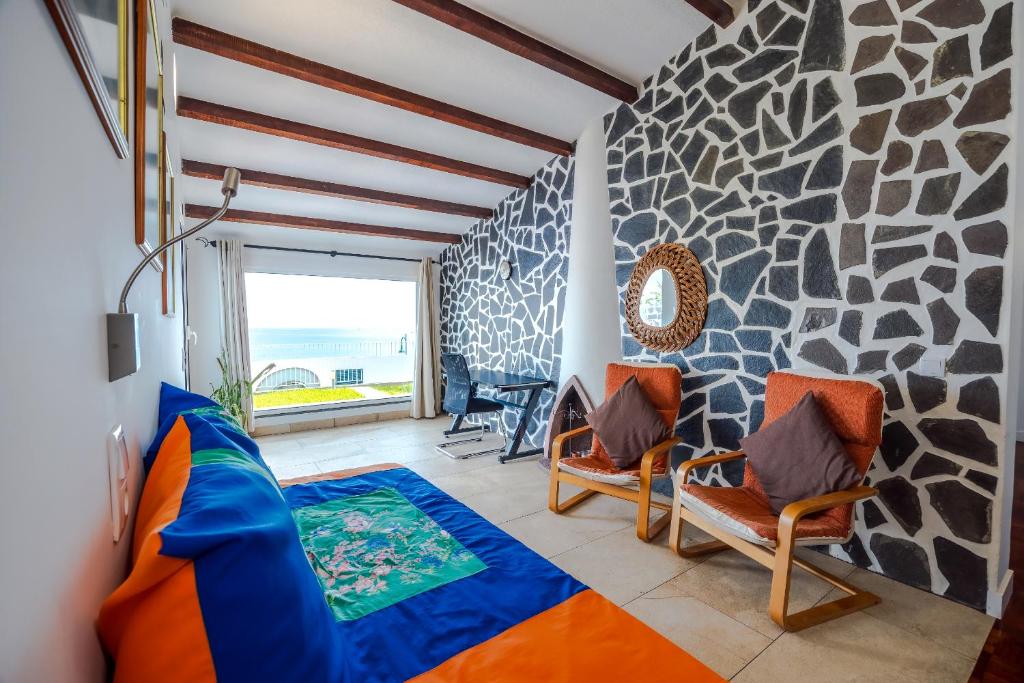 a living room with a rock wall at Casa Maravilha III in Caniço