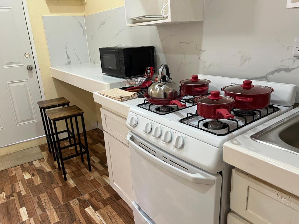 a kitchen with a stove with two pots on it at Midtown in Saint Georgeʼs