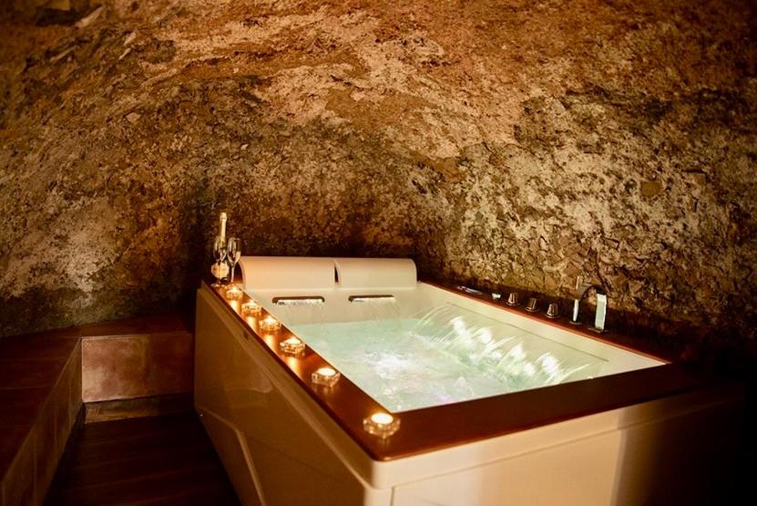 une baignoire dans une pièce avec un mur en pierre dans l'établissement Tower Cottage, à Isola del Liri
