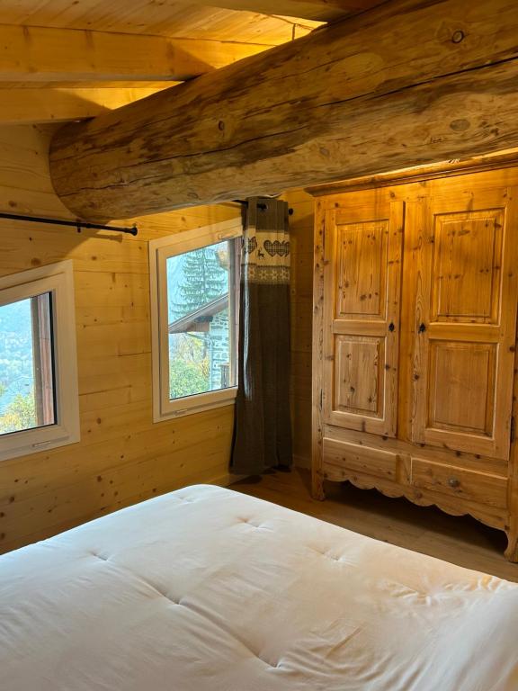 une chambre avec un lit dans une cabane en rondins dans l'établissement Chalet des balcons, à Saint-Michel-de-Maurienne