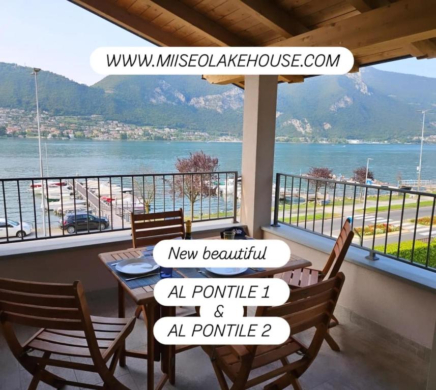 een balkon met een tafel en stoelen en uitzicht op het water bij Pontile 1 in Paratico