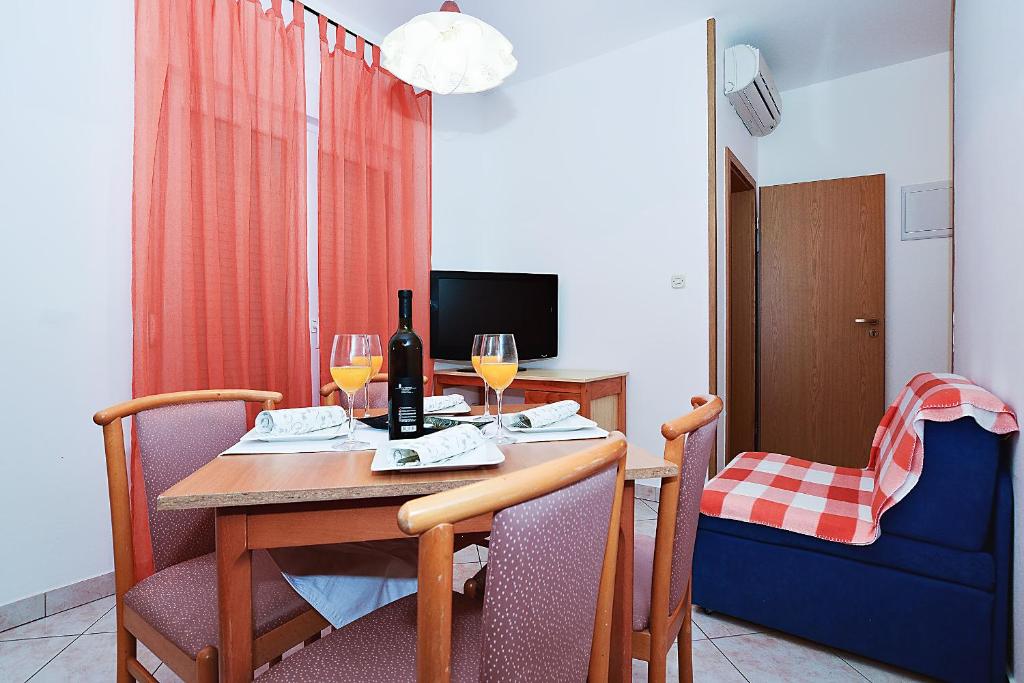 a dining room with a table with wine glasses at Apartments Lucija in Sukošan