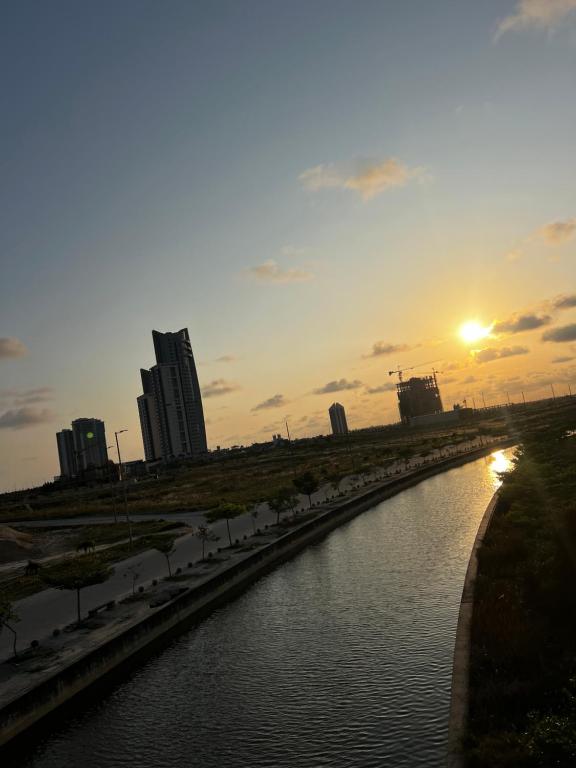 a river in a city with the sunset in the background at 2 - 4 bedroom apartments in Eko Atlantic City in Lagos