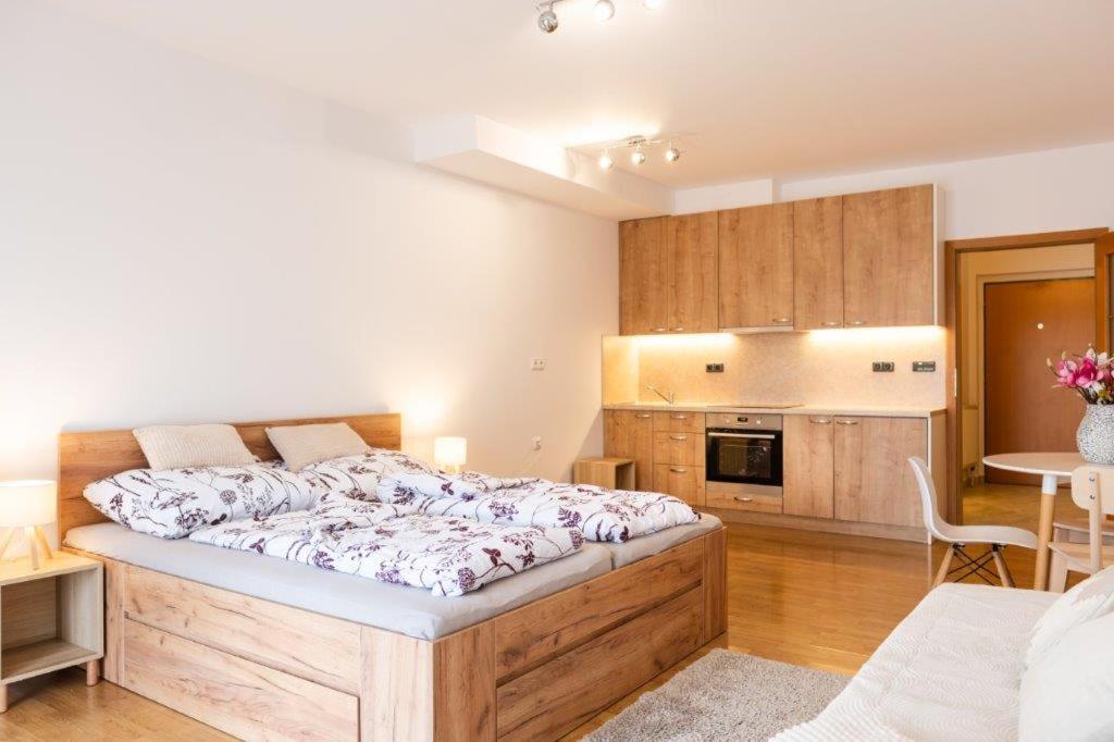 a bedroom with a large bed and a kitchen at Apartmán IRIS Poděbrady 2 in Nymburk