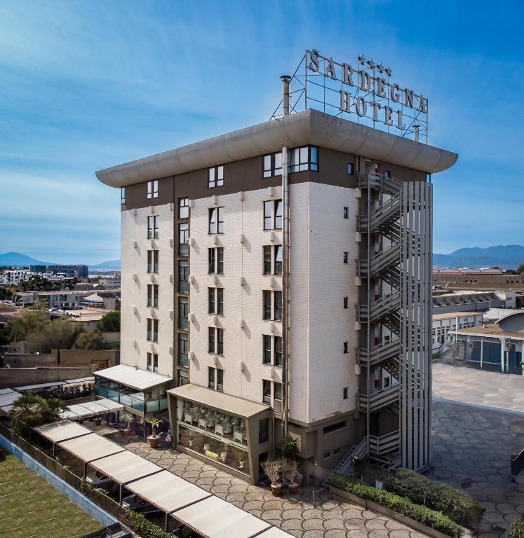 卡利亚里撒丁岛套房和餐厅酒店的一座酒店大楼,楼顶有招牌