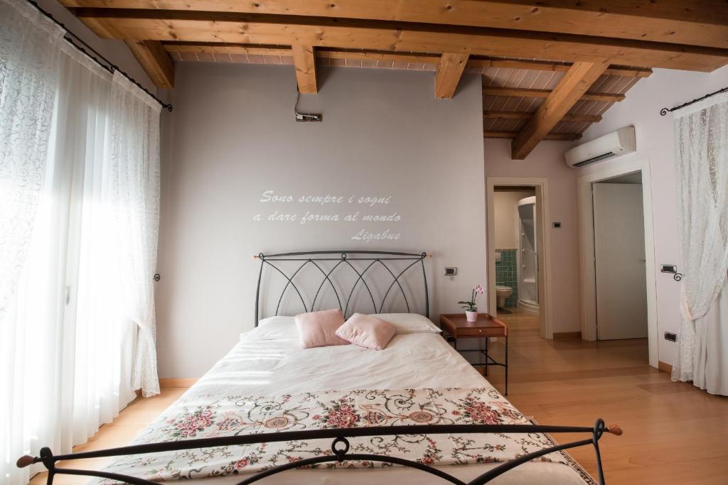 Rosa del Grappa في Rosà: غرفة نوم بسرير مكتوب على الحائط