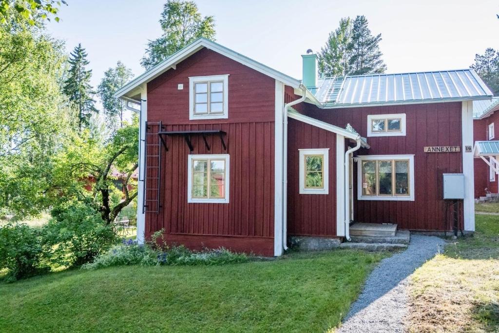 a red house with white windows and a yard at Annexet Orrabackens in Järvsö