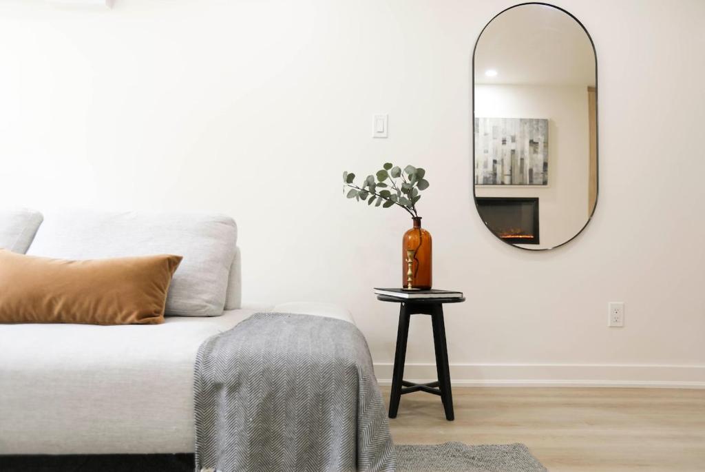 uma sala de estar com uma cama e um espelho redondo em The Ember Suite em Peterborough