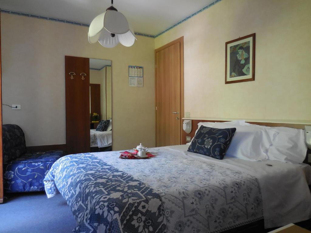 Un dormitorio con una cama grande y una bandeja. en Pensione Genzianella en Alagna Valsesia