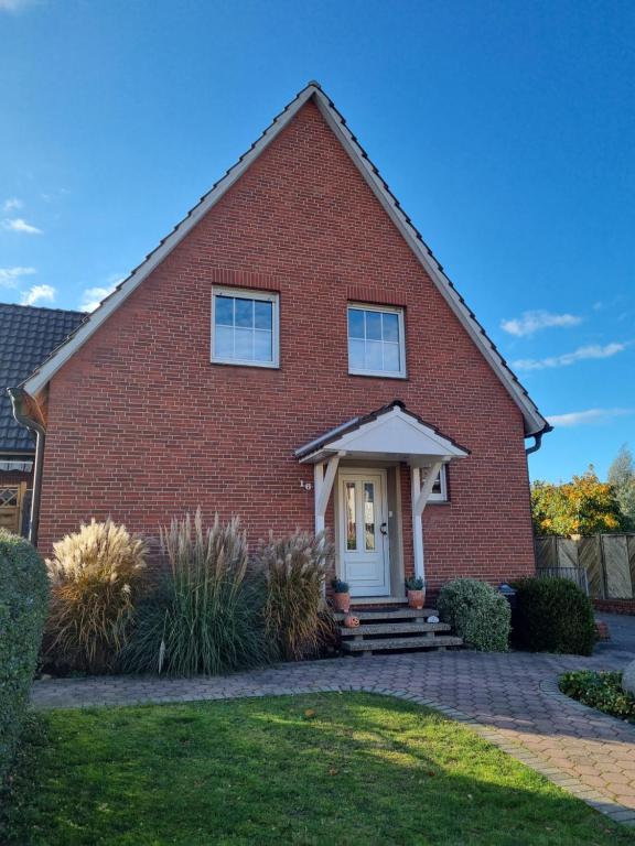 a red brick house with a white door at Ferienwohnung Wienstroer in Westbevern