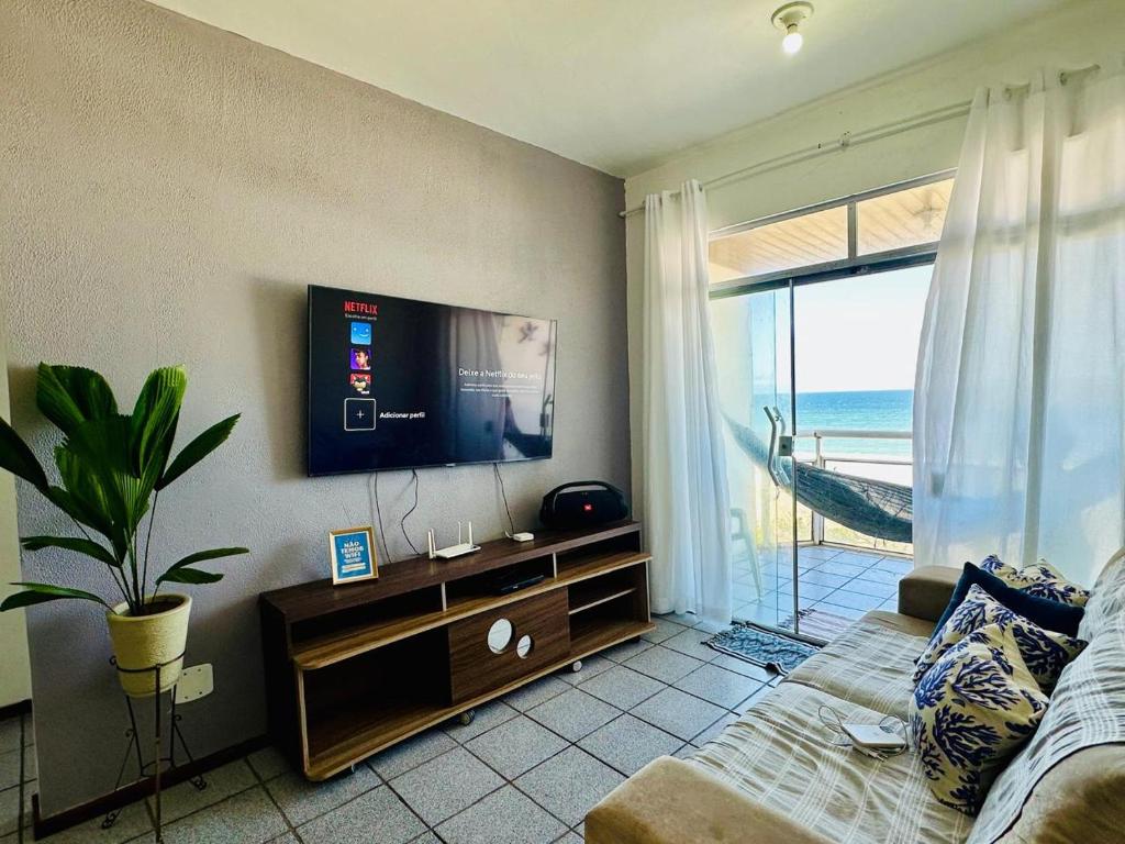 Una sala de estar con un televisor de pantalla plana en la pared. en De frente ao MAR, en Saquarema