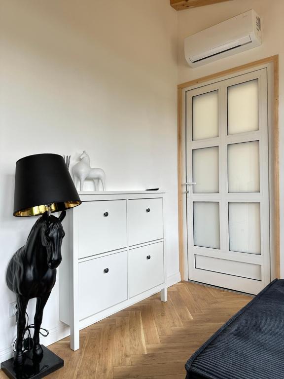 a bedroom with a black horse lamp next to a dresser at Domek Sosna 