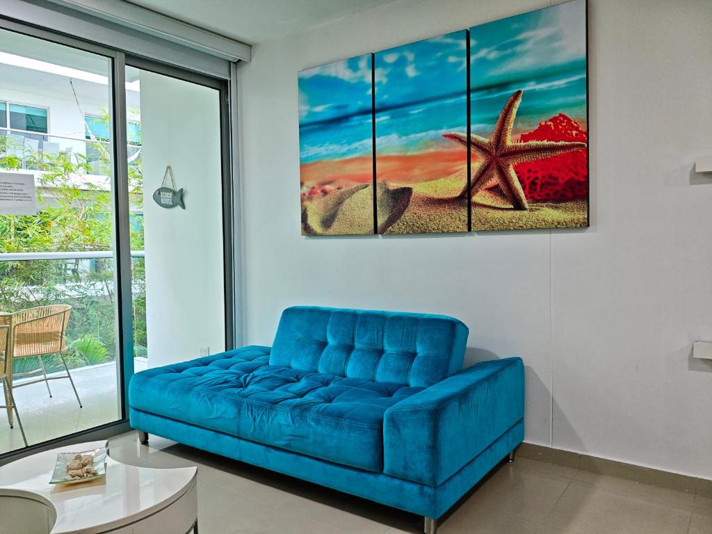 un canapé bleu dans un salon avec un tableau d'étoile de mer dans l'établissement Edificio Morros Vitri, à Carthagène des Indes