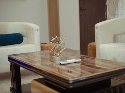 ein Wohnzimmer mit einem Couchtisch mit Fernbedienung in der Unterkunft Royaltron apartment services in Ibadan