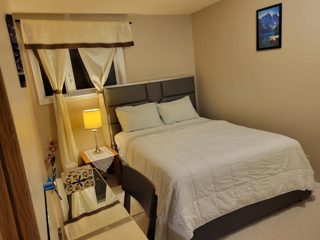 een kleine slaapkamer met een bed en een raam bij Happy night stay room in Winnipeg